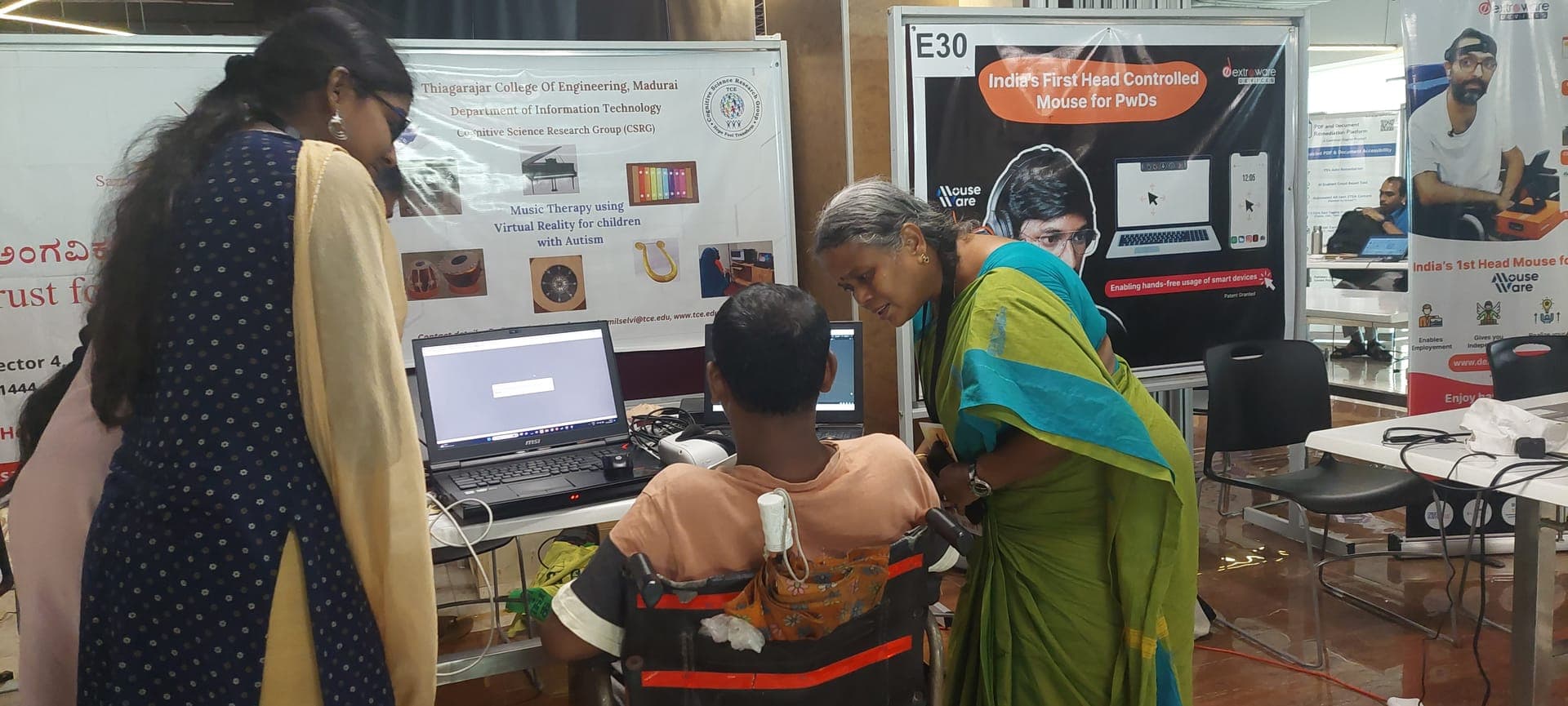 Dr. Tamilselvi helping a child in a wheelchair experience virtual reality therapy